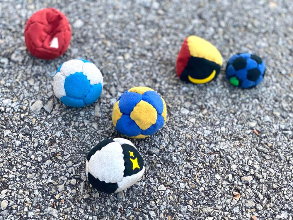 A set of footbags on concrete.