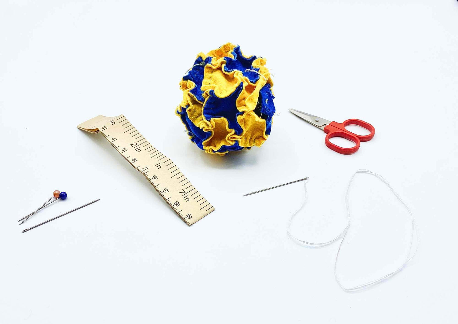 Stitching and sewing a footbag together, with needle and thread.